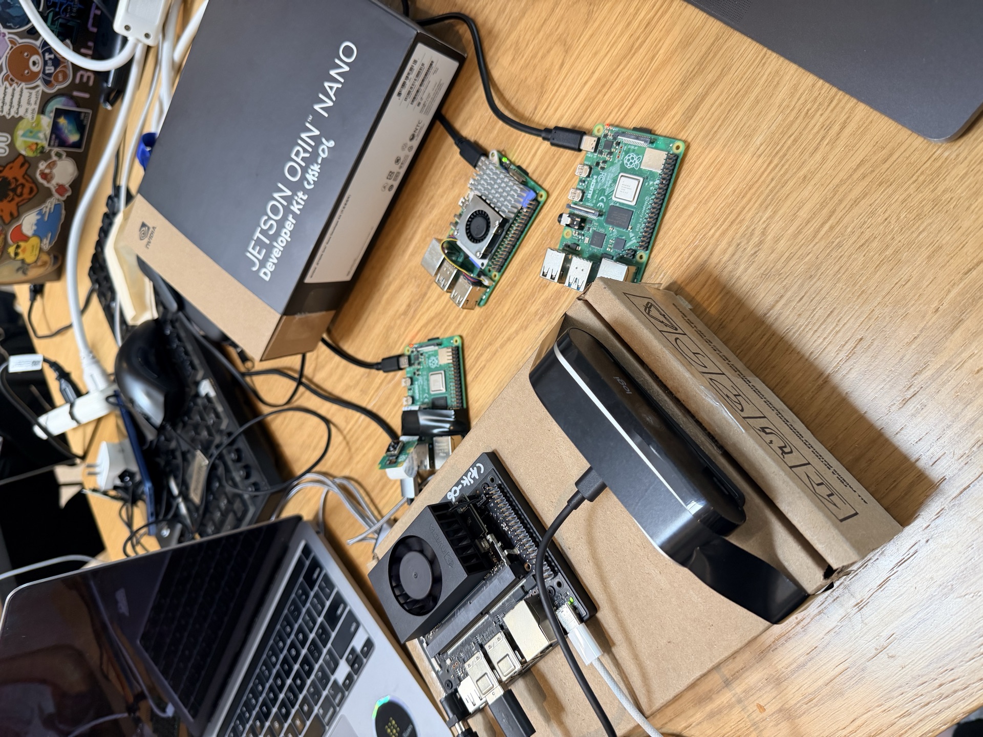 Edge fleet at the team bench: Jetson Orin Nano, Raspberry Pi 5 hub, two Pi 4B sensor peers, and iPad chest-worn operator console, joined to local Altiair-LAN over Wi-Fi